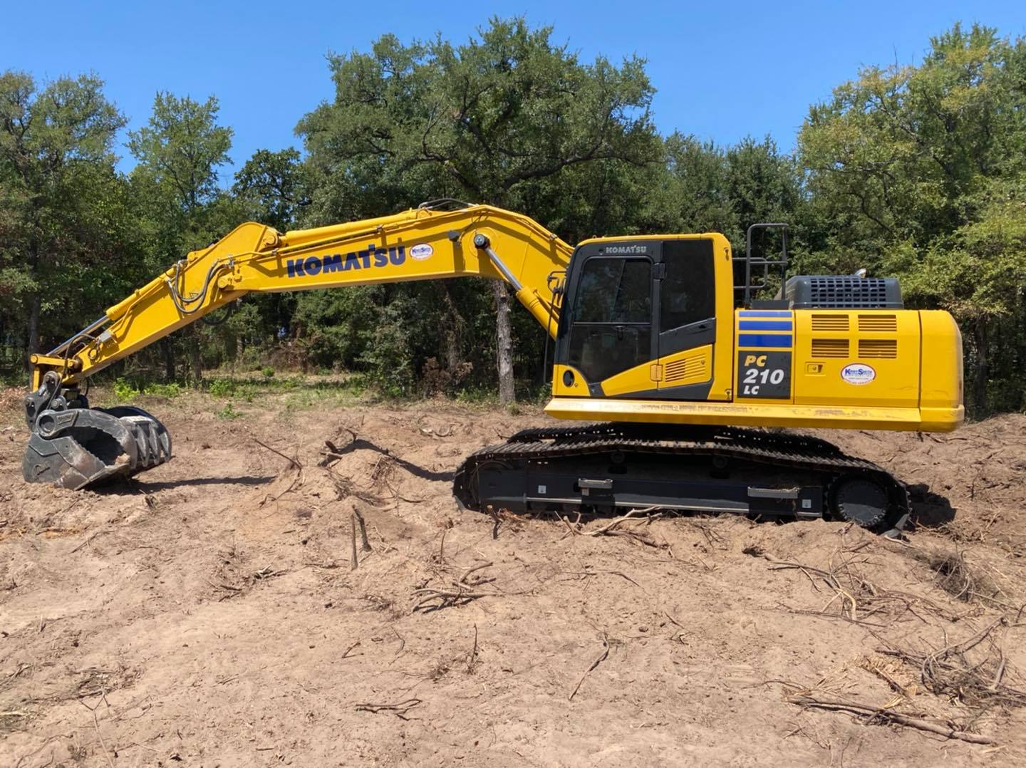 Komatsu PC210 excavator making a cut on a Central Texas site