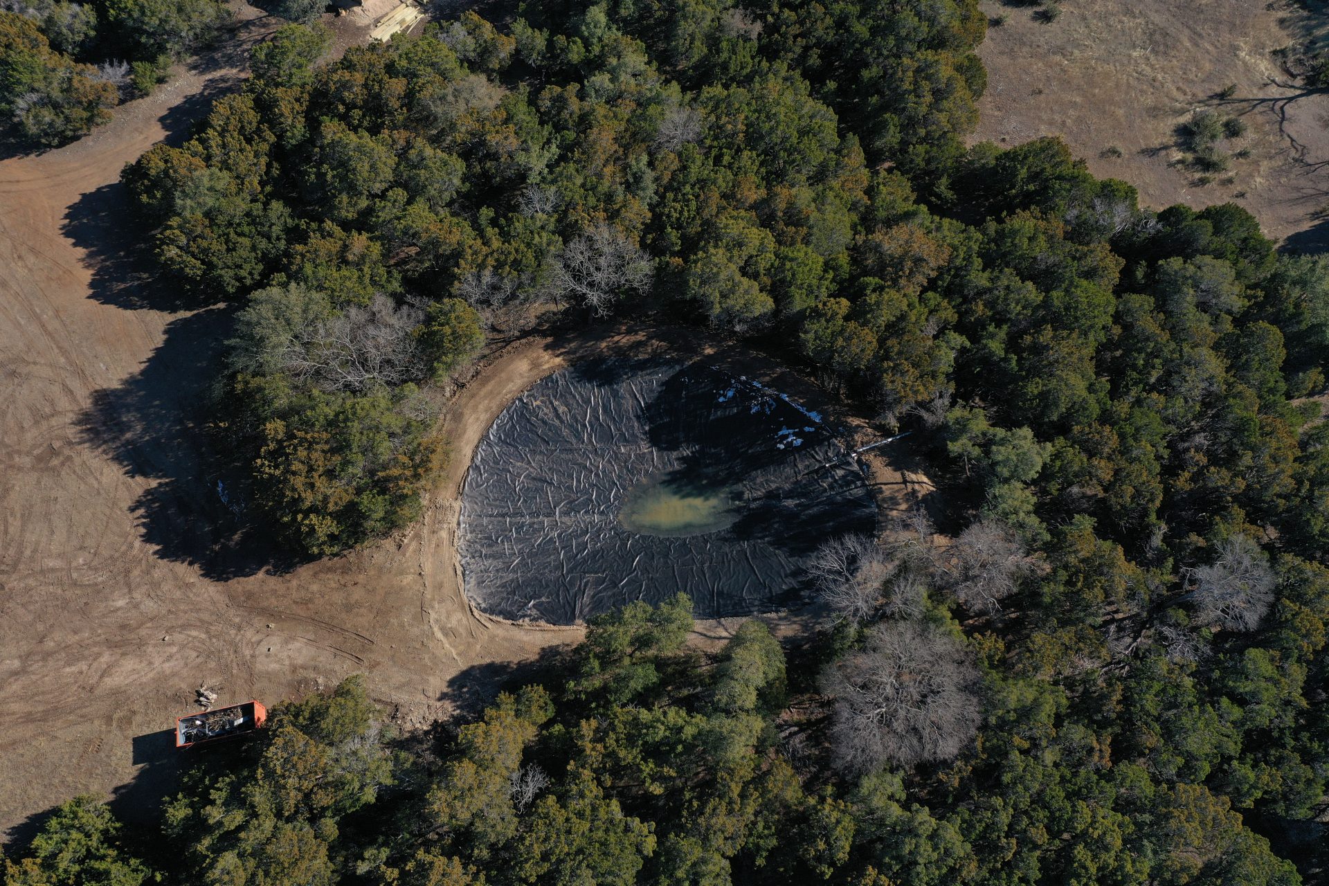 Aerial view of a lined pond built into the trees