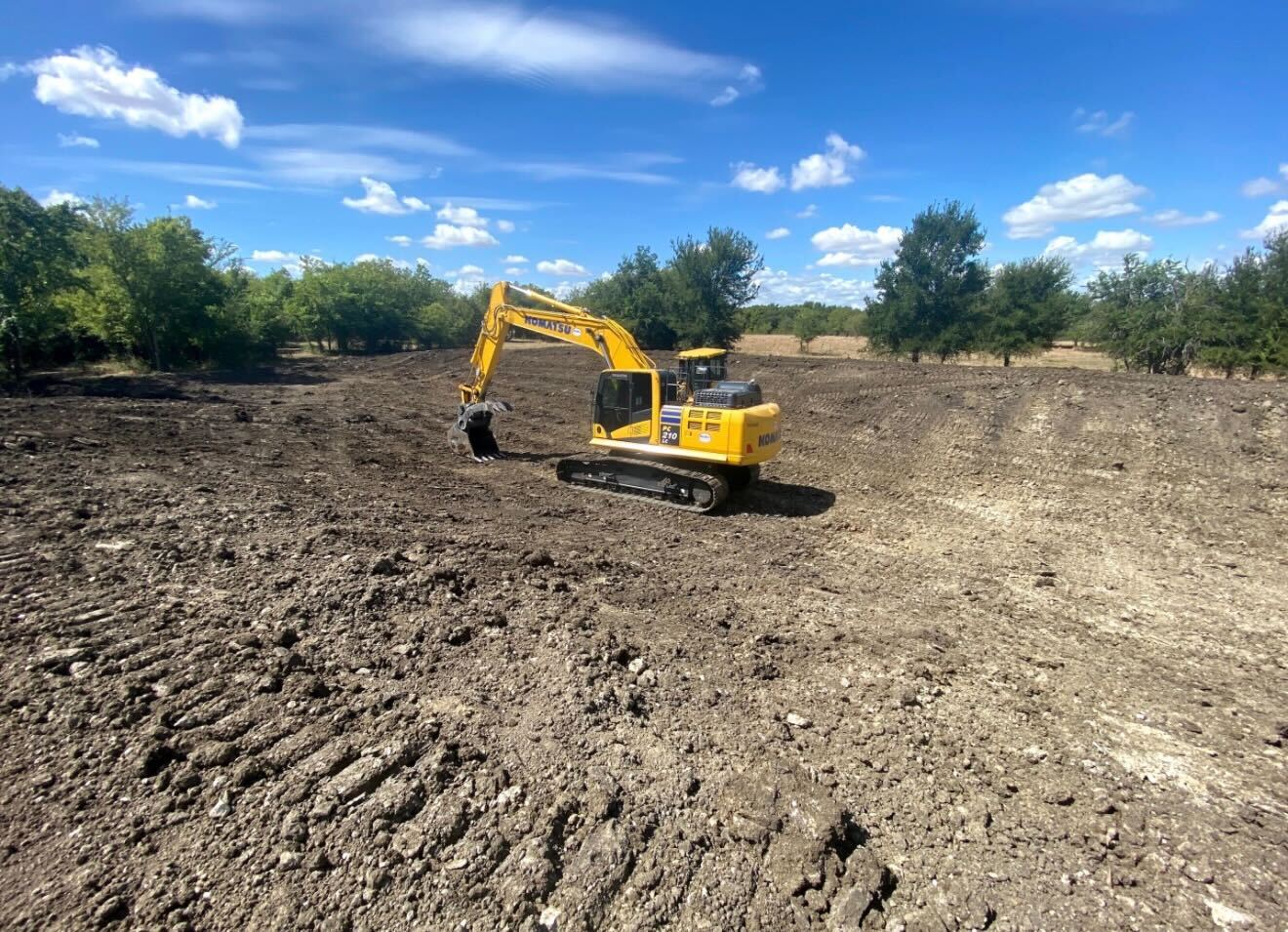 Excavator shaping a new pond basin near Gatesville Texas